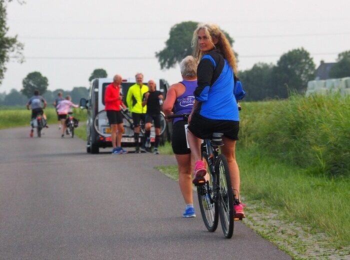Elfsteden Estafetteloop dame op fiets achterom kijkend.
