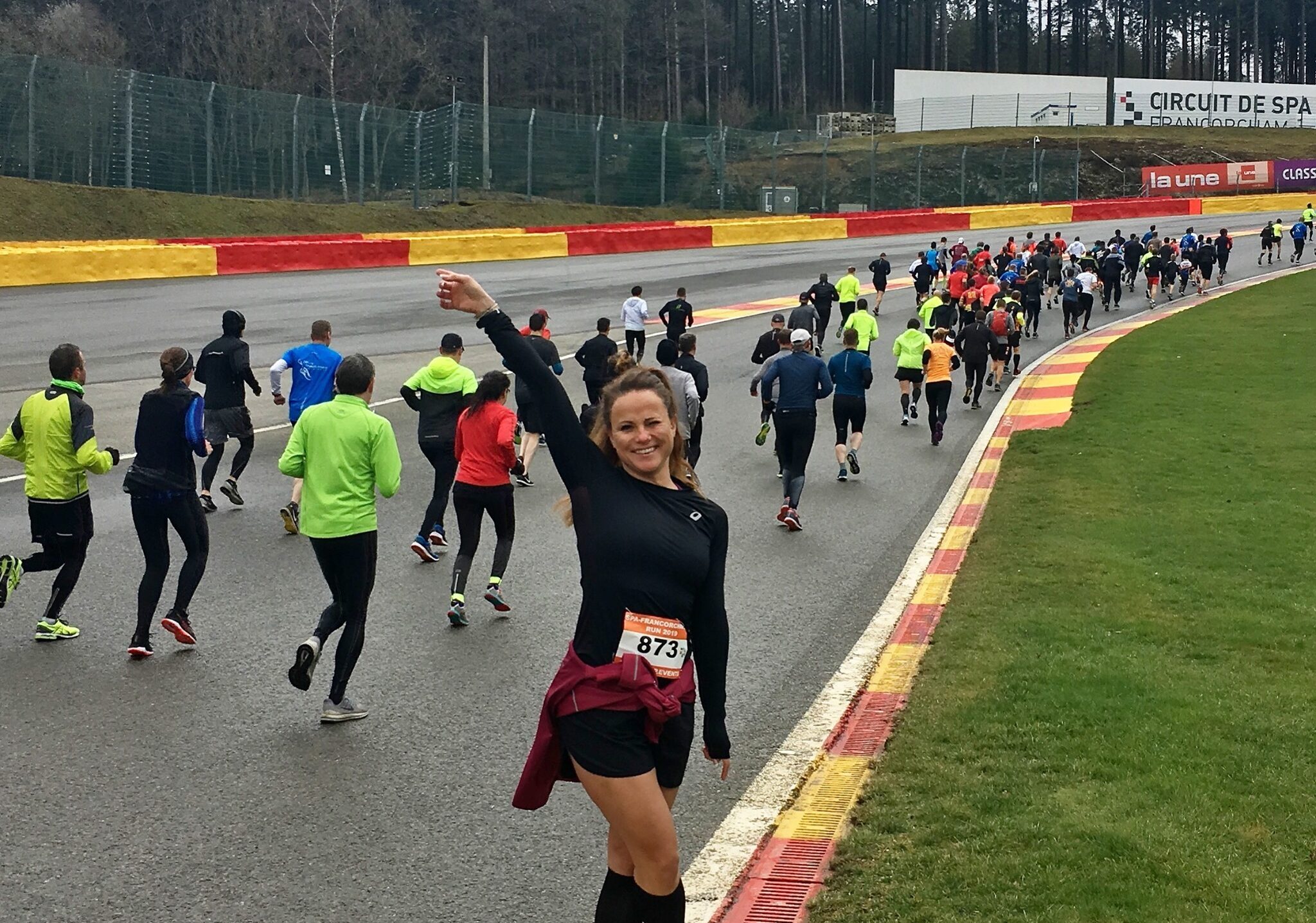 Spa-Francorchamps Run dame op circuit met arm omhoog.